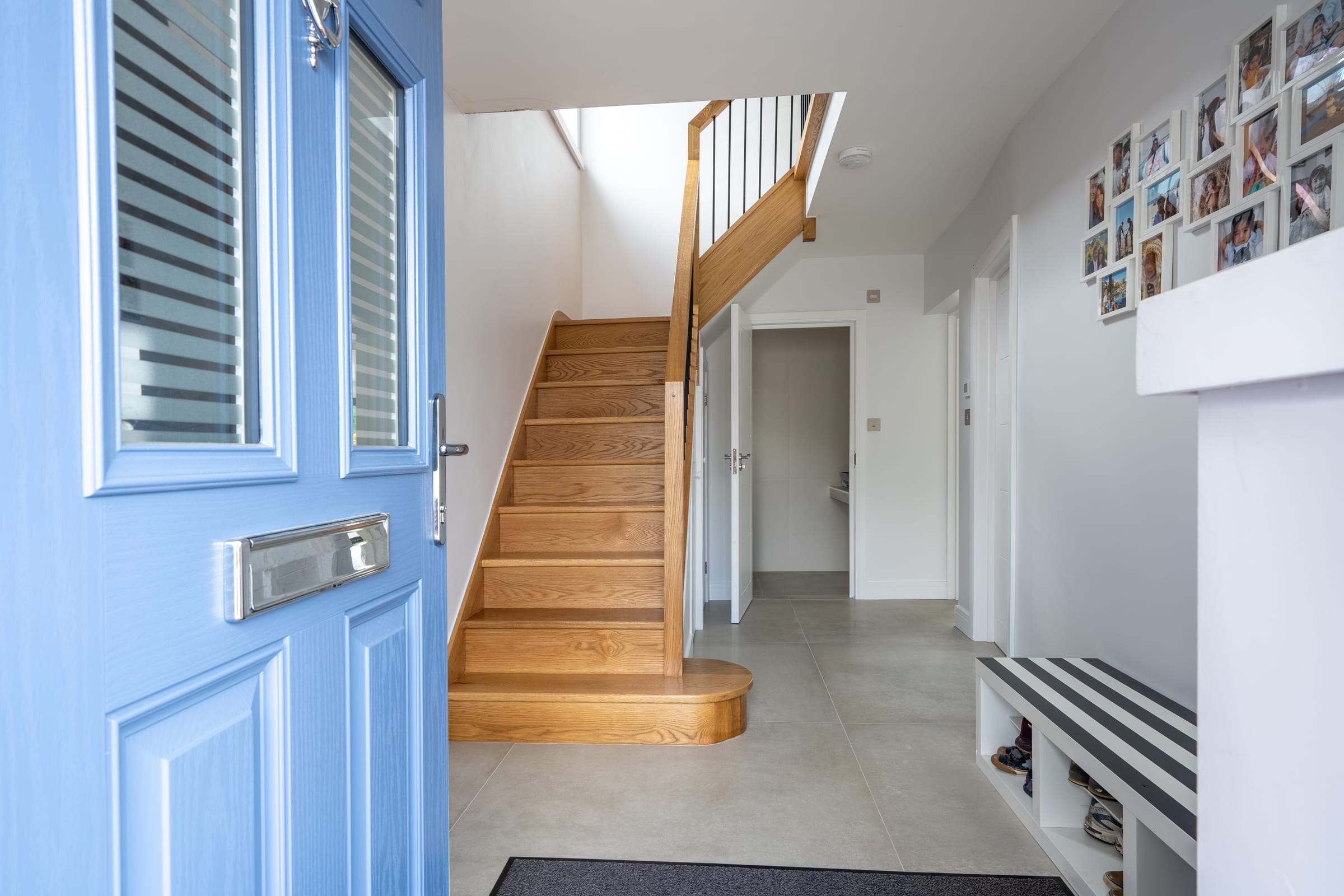 HXL entrance hall. Oak staircase, stone tile floor, blue composite door, Chorleywood.