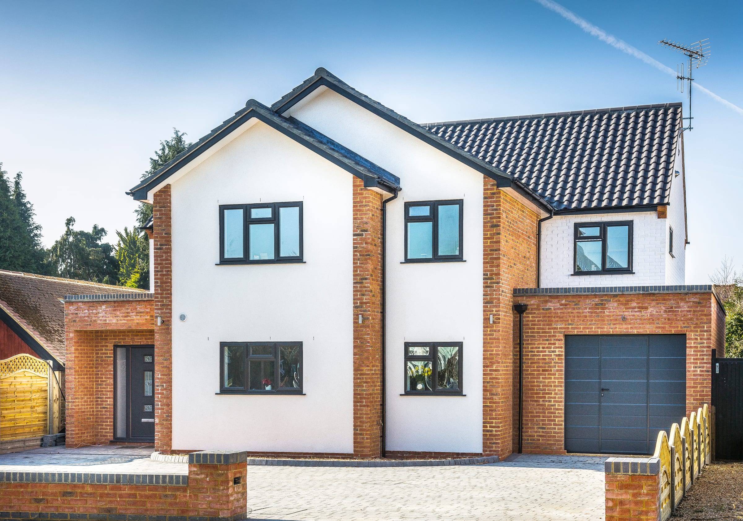 New-build family home, Pinner. Contemporary white-render and red-brick frontage, HXL residential delivery.